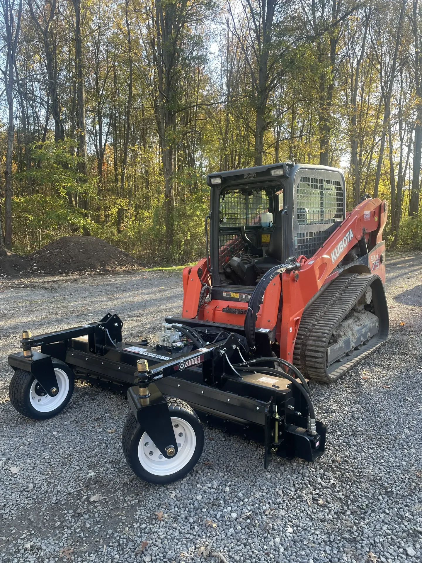 Better Way Land Management LLC Kubota SVL75 compact track loader with power rake grading attachment on gravel surface in OH