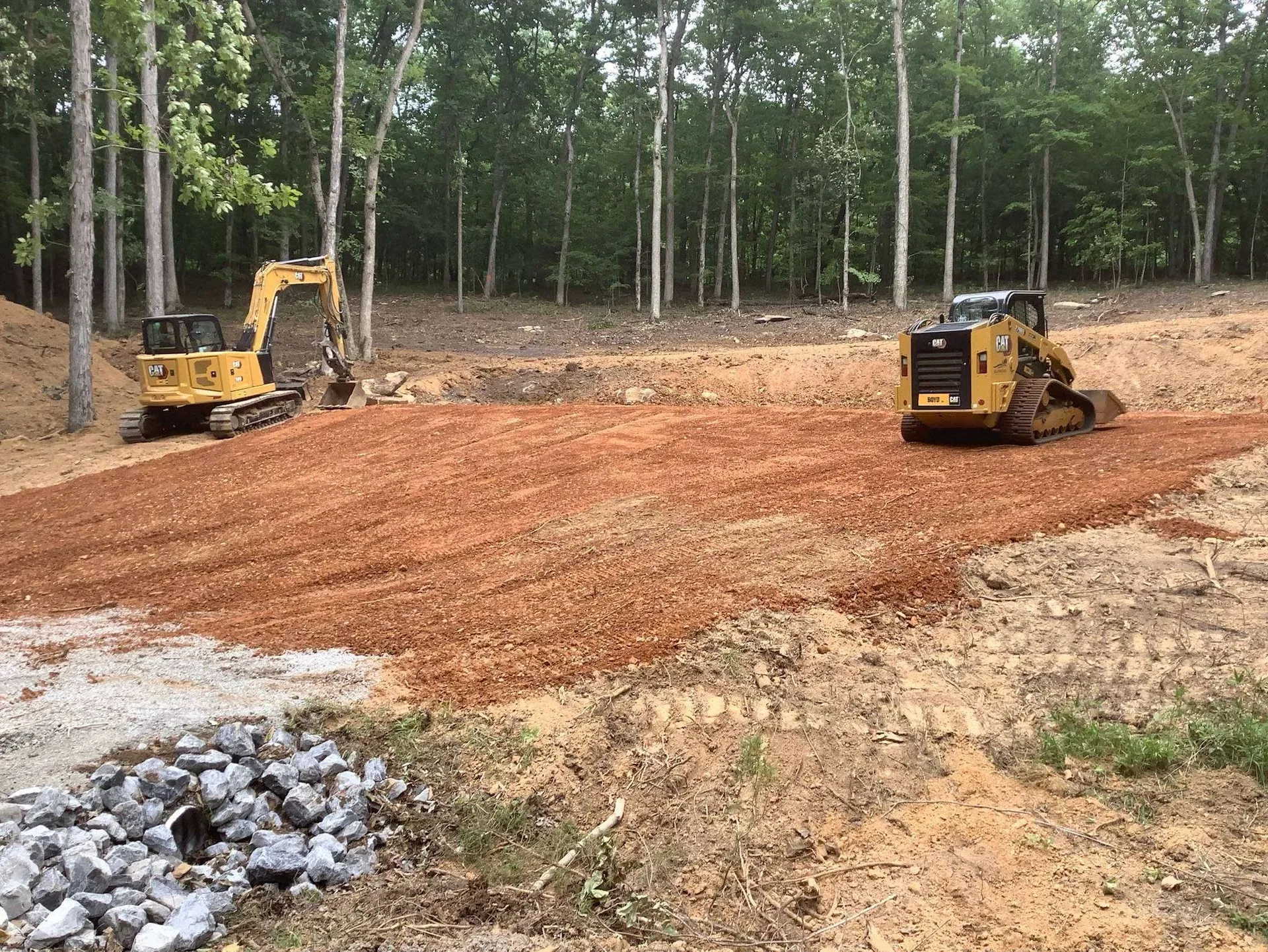 Better Way Land Management crew delivering land management services in Toledo, CAT excavator and skid steer grading a cleared wooded lot