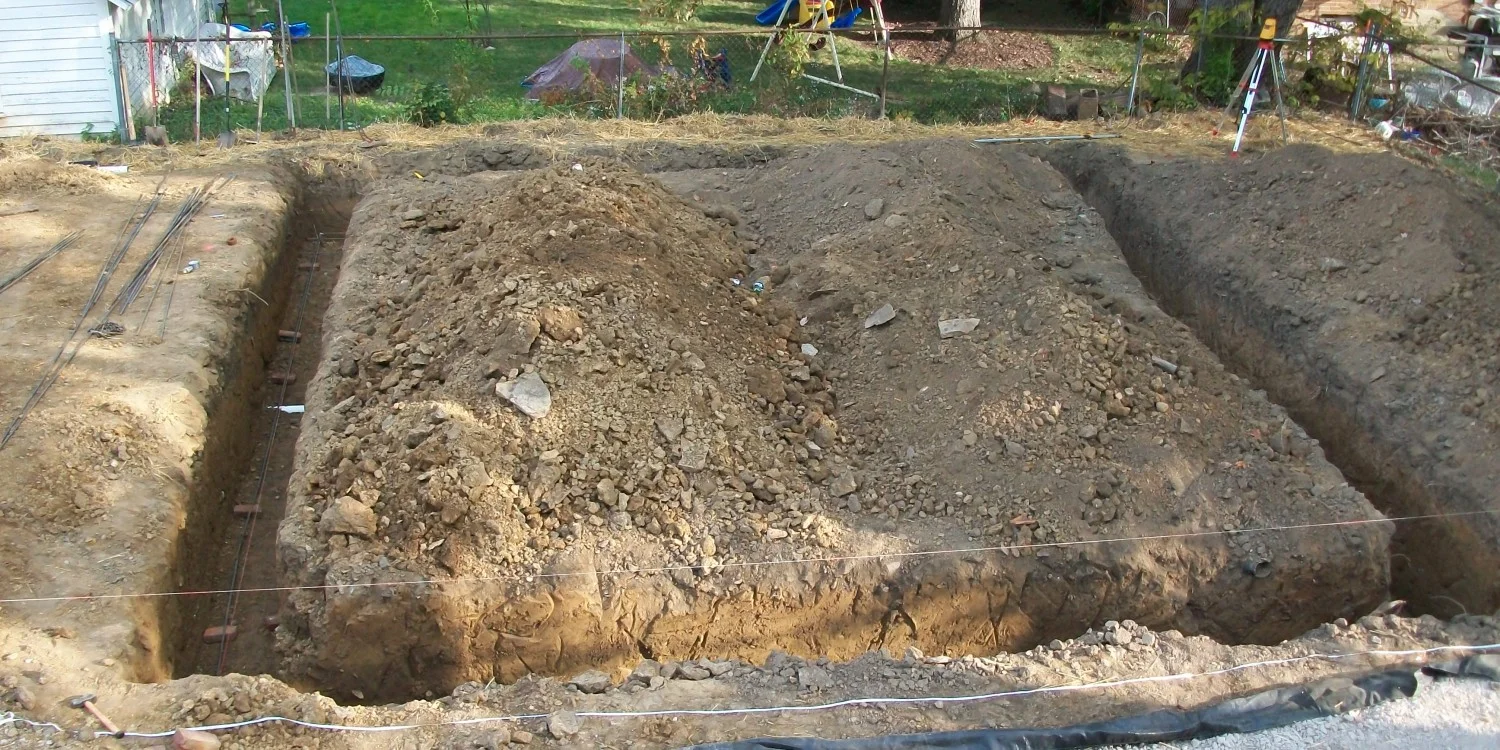 Better Way Land Management LLC foundation excavation trenches with rebar preparation in residential backyard construction site Toledo OH