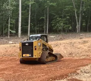 Better Way Land Management LLC CAT compact track loader grading red dirt on cleared wooded site in OH